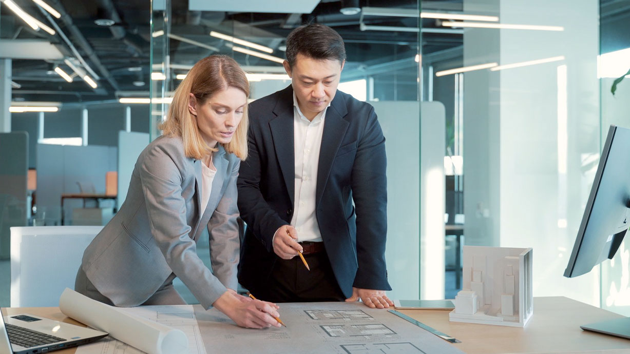 colleagues discuss a workplace floor plan